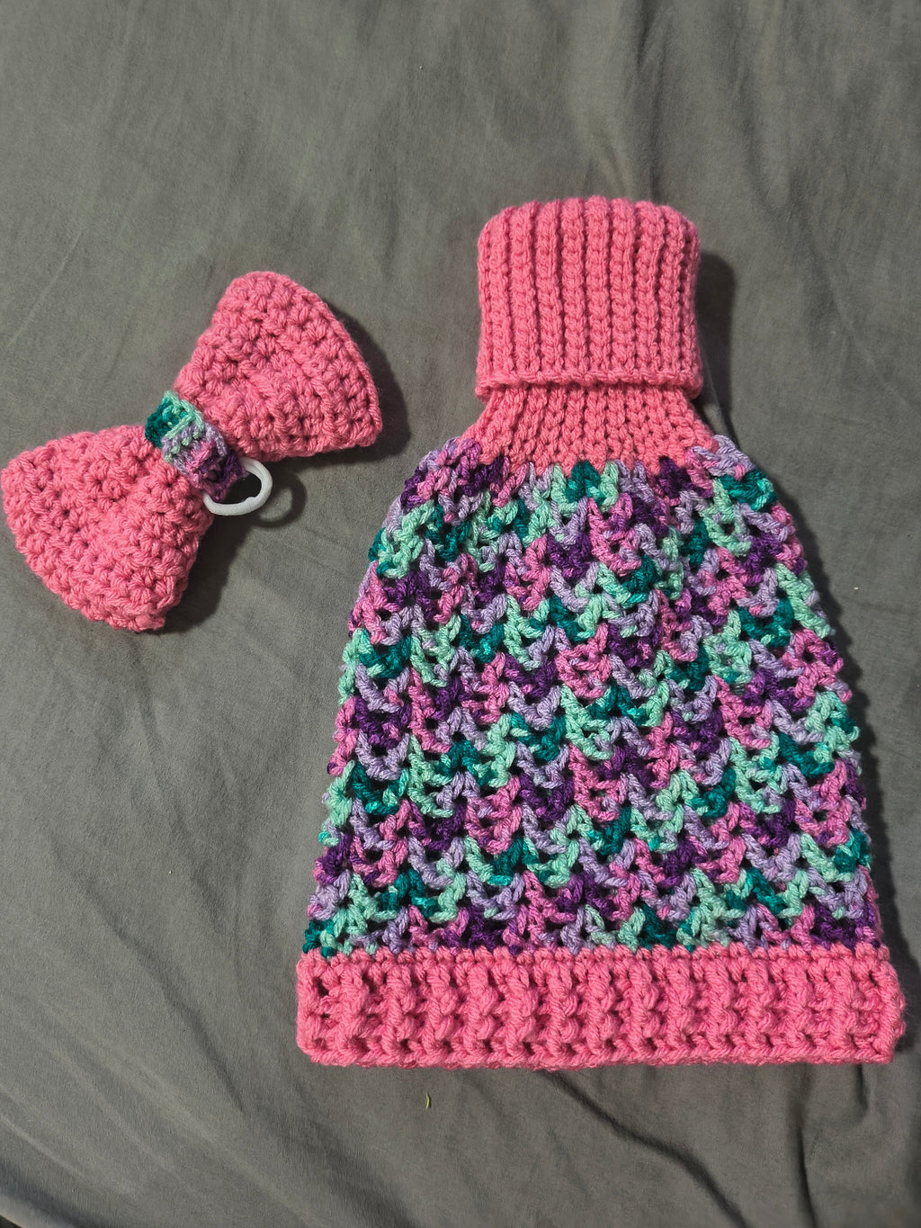 Teal crochet porch goose sweater with bow on goose statue - back view