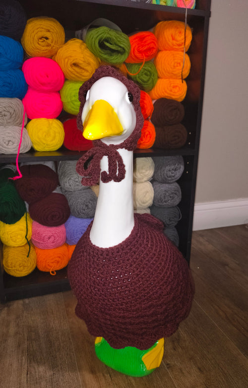 Porch goose wearing a burgundy crocheted Autumn Belle dress and matching tied bonnet.