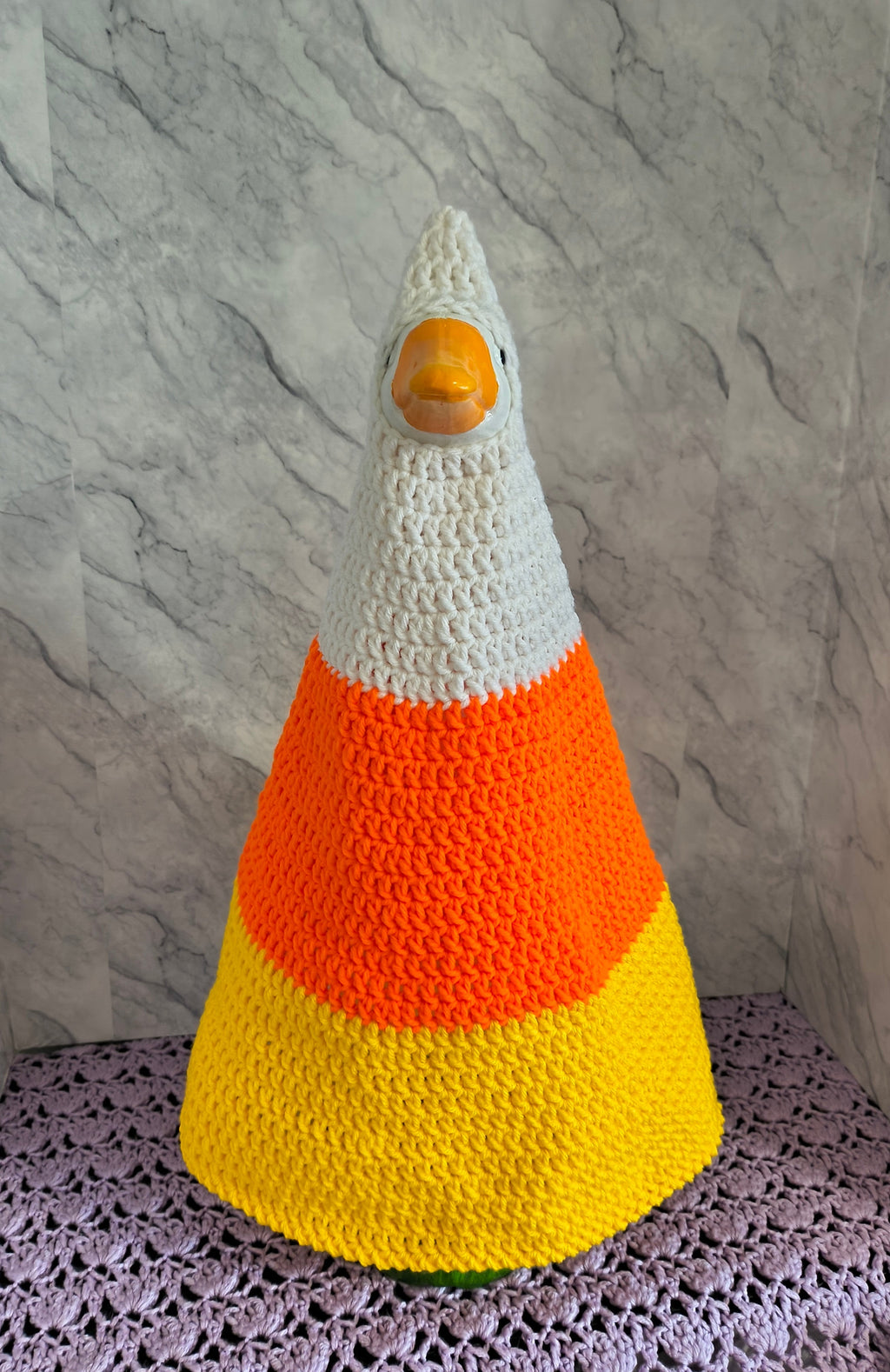 Side view of porch goose in candy corn crochet costume showing cone shape